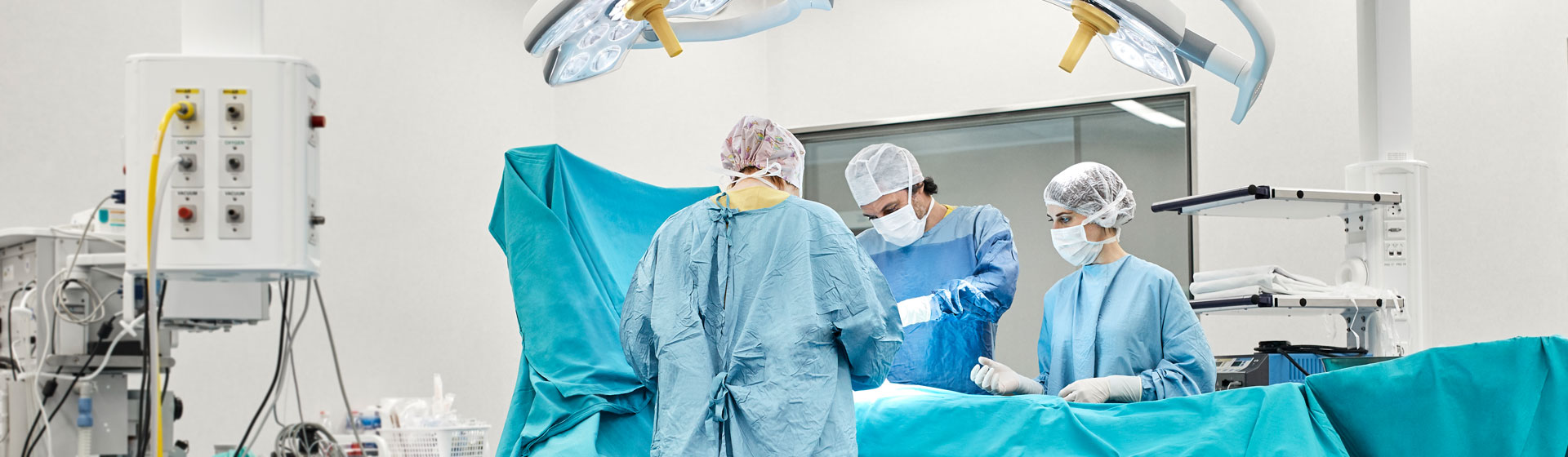 Surgeons and nurse perform surgery on patient